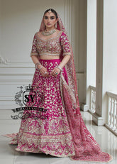The Dogwood Rose bridal look evokes an aura of ancient majesty. A richly hand-embellished lehenga choli, structured yet flowing, sparkles with dabka details, stones, sequins, beads, silk threads, and Swarovski crystals. Paired with layered raw jewels and a striking jewel-pink dupatta, it captures the grandeur of old-world bridal elegance through a contemporary lens.