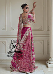 The Dogwood Rose bridal look evokes an aura of ancient majesty. A richly hand-embellished lehenga choli, structured yet flowing, sparkles with dabka details, stones, sequins, beads, silk threads, and Swarovski crystals. Paired with layered raw jewels and a striking jewel-pink dupatta, it captures the grandeur of old-world bridal elegance through a contemporary lens.
