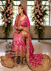 A timeless bridal dress design that exudes classic elegance and meticulous craftsmanship. The intricately crafted, opulent Banarsi Jamawar lehenga exudes a royal flair, with its heavy maroon and red borders creating a magnificent, flowing train.