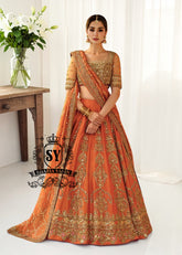 A stunning ensemble featuring Persimmon net blouse and an intricately embroidered Raw silk lehenga in the same vibrant hue. A shimmering kaamdani dupatta adds charm and sophistication to the ensemble.