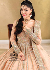 In a radiant shade of Peach puff, this bridal dress captures a timeless grandeur, sweetened with touches of pastel romance. This open-cut kalidaar gown shines with tissue silk lehenga.