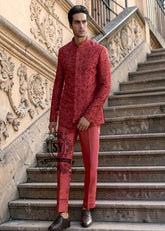 This Prince Coat embodies a mastery of proportion and structure. The prince coat, crafted from pure raw silk, features brick-red embroidery. Beneath it lies a silhouette that flows from a soft kurta to sharp, slim-fitting trousers.