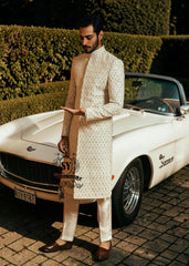 Pure royalty. A finely hand-embroidered sherwani by Shazia Yasin, elevated with gold accents, paired with a statement mala and a bold crimson turban for a timeless yet striking look.