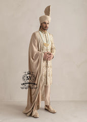 This sherwani is a masterpiece that blends timeless nobility with a modern sensibility. A finely hand-embroidered sherwani by Shazia Yasin, elevated with gold accents, paired with a statement mala, shawl and a bold turban for a timeless yet striking look.