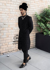 Embrace an aura of graceful distinction with our Elegant Black Sherwani, exquisitely complemented by a matching inner suit, Groom's necklace, and turban. This traditional wedding sherwani captures the very essence of refined elegance, seamlessly intertwining tradition with modern allure.