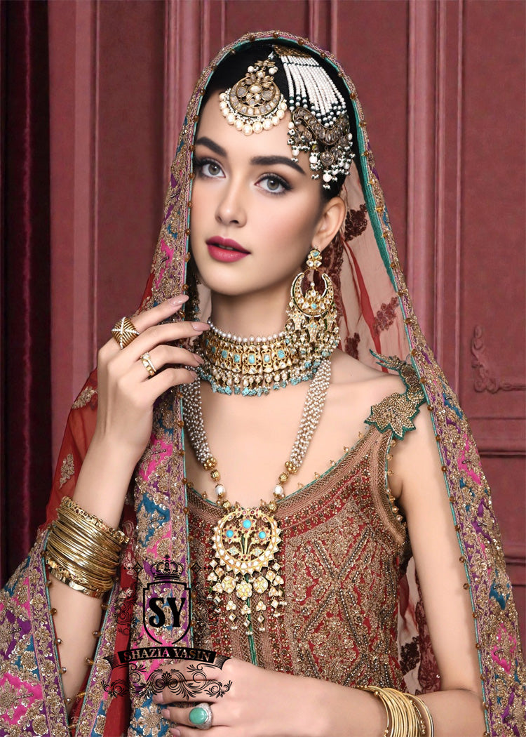 Immerse yourself in the timeless brilliance of a Pakistani couture bridal lehenga. Vibrant traditional hues of red are lightly interwoven with shimmering gold, enveloping the bride in an aura of glamour and grace.