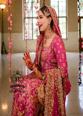 A timeless bridal dress design that exudes classic elegance and meticulous craftsmanship. The intricately crafted, opulent Banarsi Jamawar lehenga exudes a royal flair, with its heavy maroon and red borders creating a magnificent, flowing train.