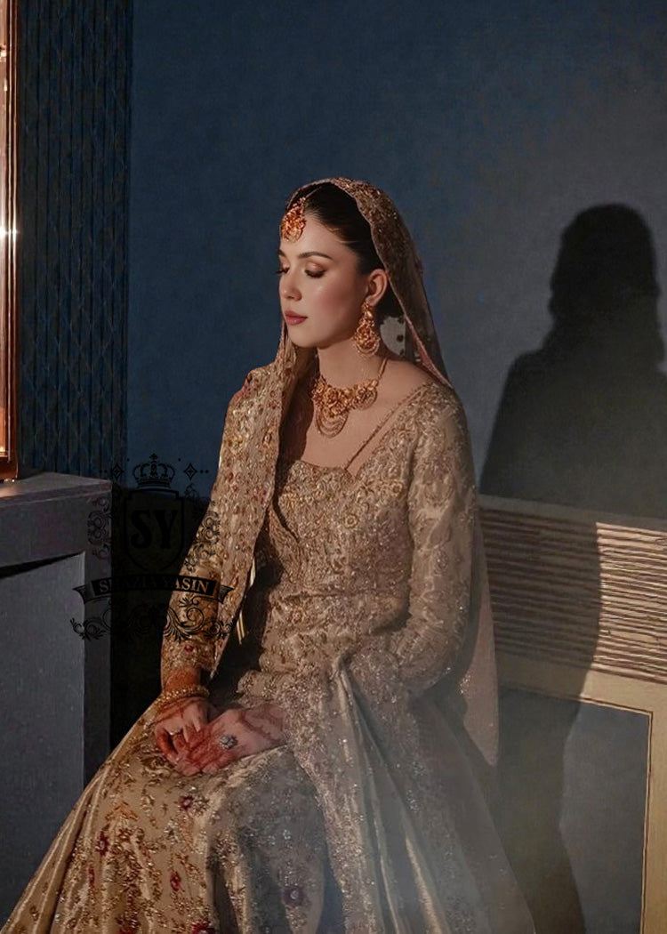 A vision of divine luminosity, this pishwas glimmers like starlight with every movement. Her Lehenga features intricate gold embroidery, delicate florals and crystal embellishments, while her lame dupatta envelops her like a dream.