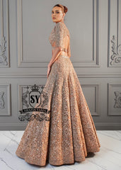 The essence of romance reimagined into a showstopping Lehenga silhouette. This bridal dress features a sculpted choli bodice with a dramatic front waist and daring sheer side cutouts, creating an interplay of strength and sensuality.