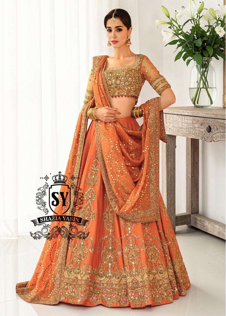 A stunning ensemble featuring Persimmon net blouse and an intricately embroidered Raw silk lehenga in the same vibrant hue. A shimmering kaamdani dupatta adds charm and sophistication to the ensemble.
