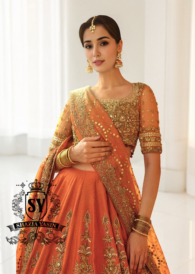 A stunning ensemble featuring Persimmon net blouse and an intricately embroidered Raw silk lehenga in the same vibrant hue. A shimmering kaamdani dupatta adds charm and sophistication to the ensemble.