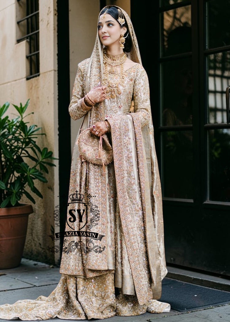 A majestic wedding dress made of luxurious Lame fabric in a lush farshi lehenga silhouette that radiates elegance. Long shirt creates an exquisite effect. The decor in the form of delicate flourishing embellishments adds romance.