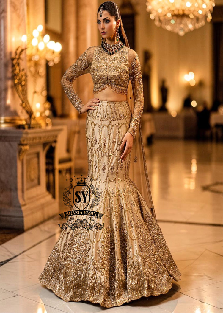 Ivy is a mermaid wedding dress that fascinates with the refinement of its lehenga silhouette, which delicately follows the lines of the body and highlights a timeless elegance. The blouse of the dress is outlined by a embellished neckline, while the long sleeves, made entirely of net with shiny floral embellishments, add an extra touch of sophistication.