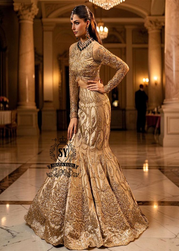 Ivy is a mermaid wedding dress that fascinates with the refinement of its lehenga silhouette, which delicately follows the lines of the body and highlights a timeless elegance. The blouse of the dress is outlined by a embellished neckline, while the long sleeves, made entirely of net with shiny floral embellishments, add an extra touch of sophistication.