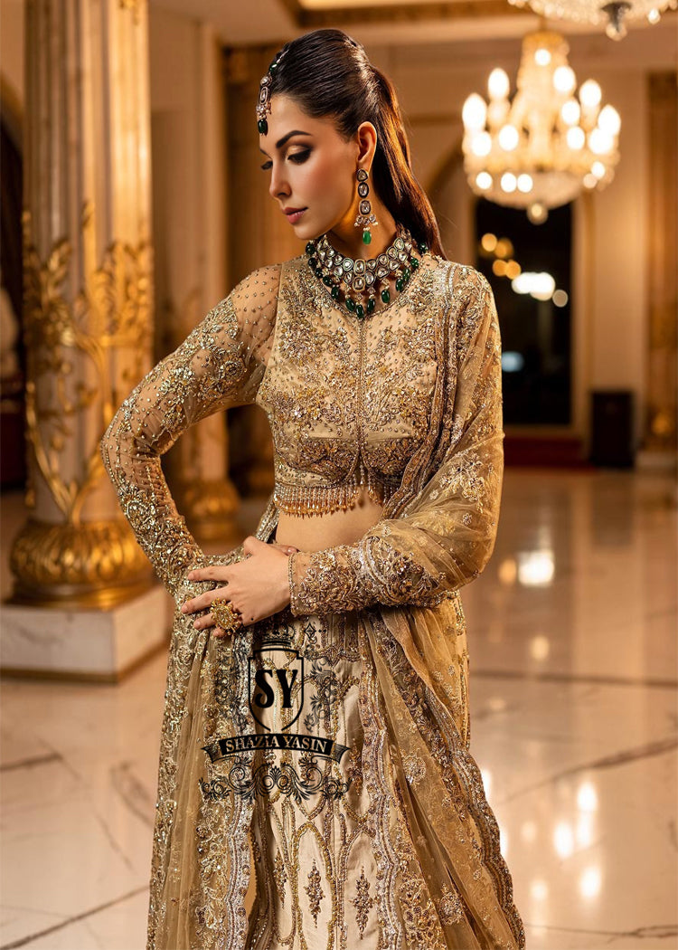 Ivy is a mermaid wedding dress that fascinates with the refinement of its lehenga silhouette, which delicately follows the lines of the body and highlights a timeless elegance. The blouse of the dress is outlined by a embellished neckline, while the long sleeves, made entirely of net with shiny floral embellishments, add an extra touch of sophistication.