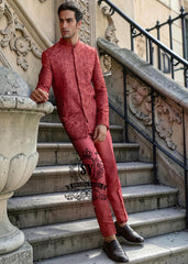 This Prince Coat embodies a mastery of proportion and structure. The prince coat, crafted from pure raw silk, features brick-red embroidery. Beneath it lies a silhouette that flows from a soft kurta to sharp, slim-fitting trousers.