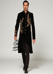 The Rich Black Sherwani jacket with a mandarin collar and jeweled shimmering gold zari embellishments on the front evokes regal elegance, reinterpreted with a modern twist.