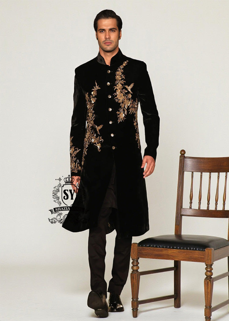 The Rich Black Sherwani jacket with a mandarin collar and jeweled shimmering gold zari embellishments on the front evokes regal elegance, reinterpreted with a modern twist.