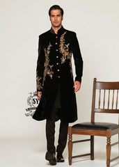 The Rich Black Sherwani jacket with a mandarin collar and jeweled shimmering gold zari embellishments on the front evokes regal elegance, reinterpreted with a modern twist.