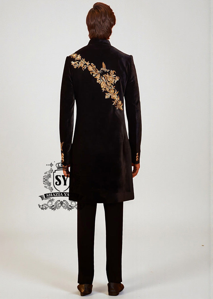 The Rich Black Sherwani jacket with a mandarin collar and jeweled shimmering gold zari embellishments on the front evokes regal elegance, reinterpreted with a modern twist.