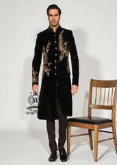 The Rich Black Sherwani jacket with a mandarin collar and jeweled shimmering gold zari embellishments on the front evokes regal elegance, reinterpreted with a modern twist.