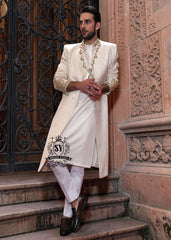 The Luminescence Ivory White Sherwani is a vision of refined romance, crafted in luminous karandi silk that seems to glow with elegance—hand embellishments on the collar and sleeves whispers of heritage artistry,