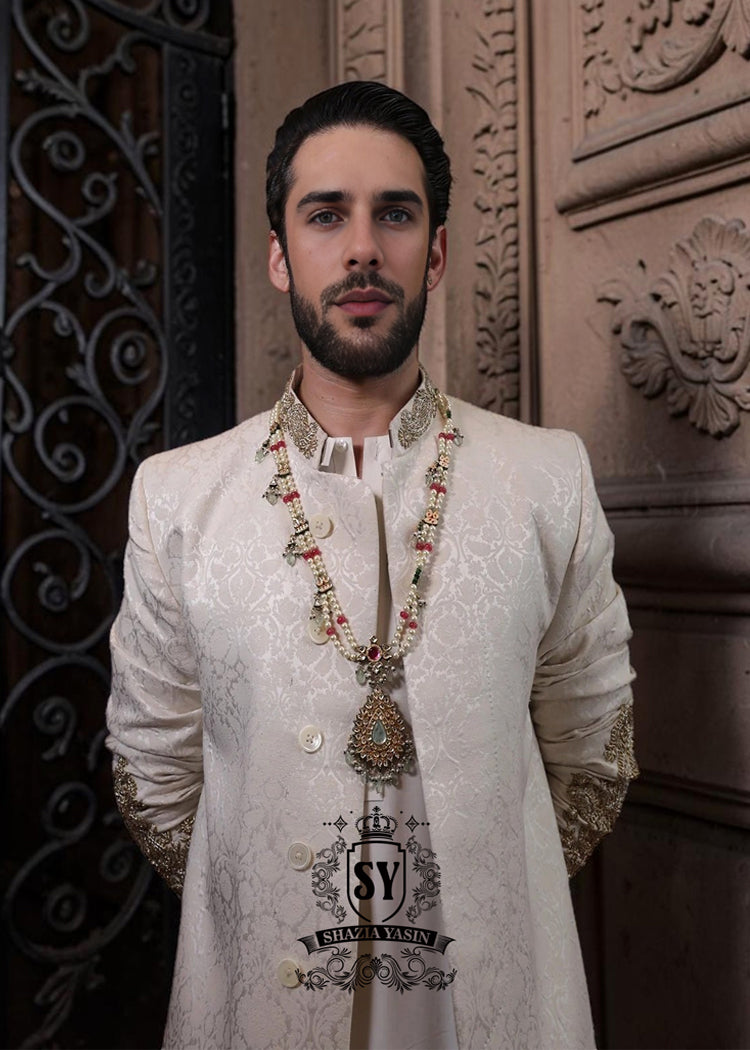 The Luminescence Ivory White Sherwani is a vision of refined romance, crafted in luminous karandi silk that seems to glow with elegance—hand embellishments on the collar and sleeves whispers of heritage artistry,