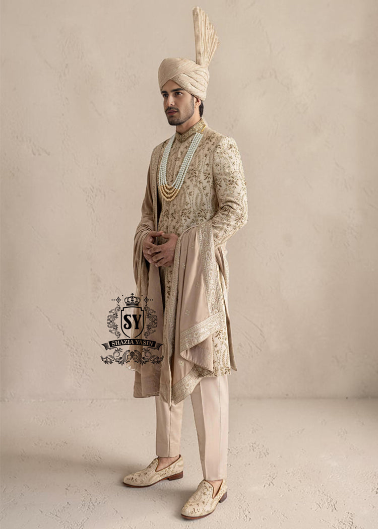 This sherwani is a masterpiece that blends timeless nobility with a modern sensibility. A finely hand-embroidered sherwani by Shazia Yasin, elevated with gold accents, paired with a statement mala, shawl and a bold turban for a timeless yet striking look.