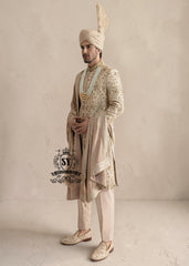 This sherwani is a masterpiece that blends timeless nobility with a modern sensibility. A finely hand-embroidered sherwani by Shazia Yasin, elevated with gold accents, paired with a statement mala, shawl and a bold turban for a timeless yet striking look.