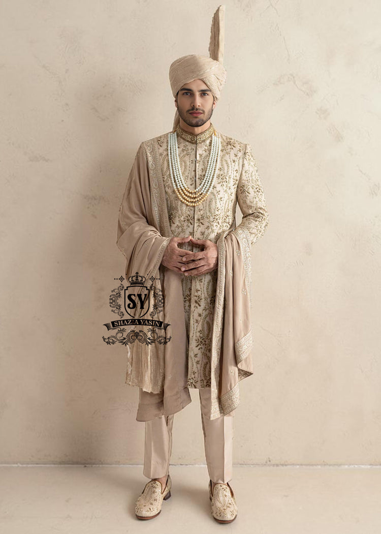 This sherwani is a masterpiece that blends timeless nobility with a modern sensibility. A finely hand-embroidered sherwani by Shazia Yasin, elevated with gold accents, paired with a statement mala, shawl and a bold turban for a timeless yet striking look.