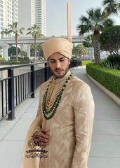 In the grandeur of royal legacy, this Taupe Gold sherwani stands as a tribute to timeless nobility. Handcrafted with intricate embroidery that echo strength and majesty, it glimmers with the delicate artistry of sequins, Swarovski crystals. A creation where tradition meets elegance - designed for the groom who carries the spirit of heritage with the poise of modern royalty.