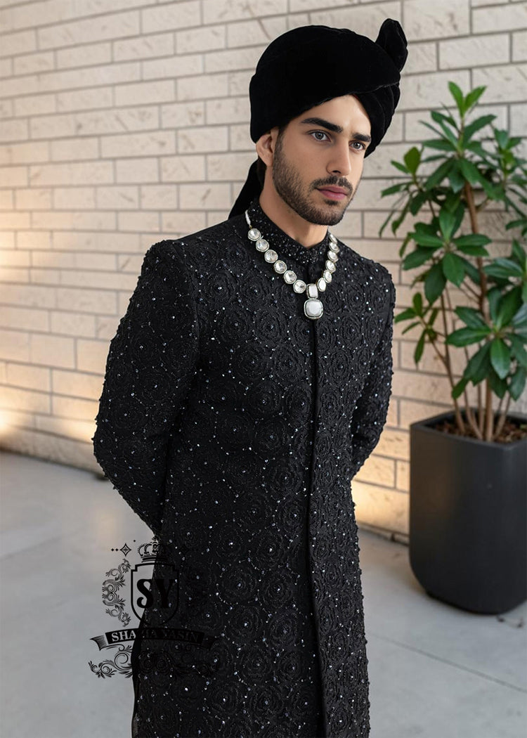 Embrace an aura of graceful distinction with our Elegant Black Sherwani, exquisitely complemented by a matching inner suit, Groom's necklace, and turban. This traditional wedding sherwani captures the very essence of refined elegance, seamlessly intertwining tradition with modern allure.