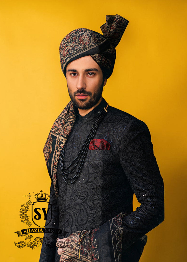 Wrapped in a rich black Sherwani with lustrous Self-embroidery and precise tailoring, this Sherwani defines luxury. A perfect balance of refinement, confidence and iconic black.