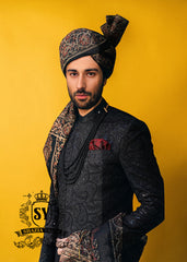 Wrapped in a rich black Sherwani with lustrous Self-embroidery and precise tailoring, this Sherwani defines luxury. A perfect balance of refinement, confidence and iconic black.