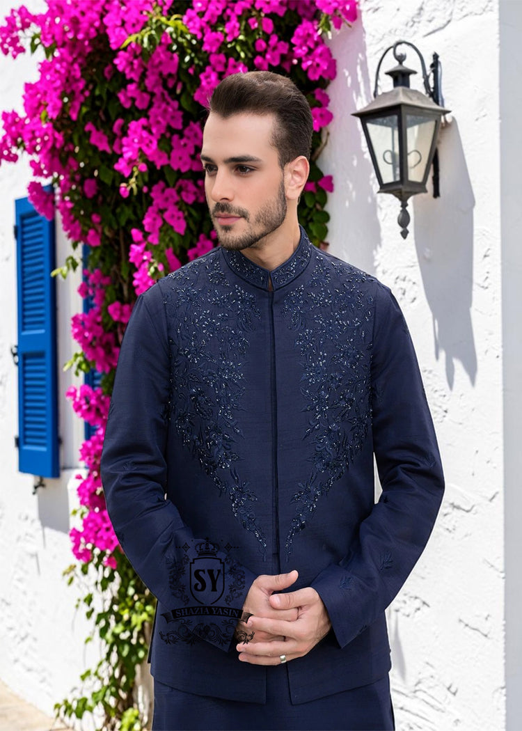 A stylish waistcoat crafted from luxurious navy blue raw silk fabric. The waistcoat itself, the front, and the sleeves are adorned with intricate threadwork and embroidery, giving it a refined and traditional feel.